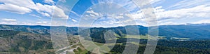 panoramic wide banner view of a Chike-Taman pass in the Altai mountains with green trees, Blue sky and clouds