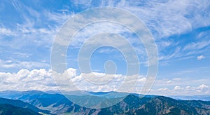 panoramic wide banner view of a Chike-Taman pass in the Altai mountains with green trees, Blue sky and clouds