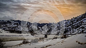 Panoramic winter landscape of a frozen bridge over the Missouri river captured at sunset