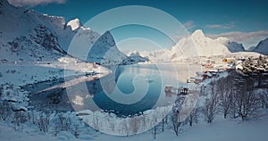 Panoramic winter landscape with snowcapped mountains and Sakrisoy village,nordic houses of Lofoten islands, Norway