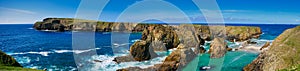 A panorams of the rugged coastal cliff scenery and pristine turquoise waters around the island of Uyea in Northmavine, Shetland,