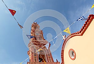 Panormitis Monastery bell tower and flags. Symi island, Greece.