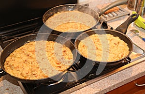 Pans with the food named frico a typical italian dish with potat