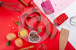 Pans hearts mold, whisk, eggs, wooden spatula and grated chocolate. Ingredients to making festive cake. Valentines Day bakeware