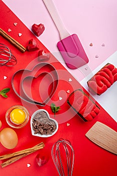 Pans hearts mold, whisk, eggs, wooden spatula and grated chocolate. Ingredients to making festive cake. Valentines Day bakeware