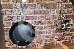 Pans stove hung on brick wall of kitchen