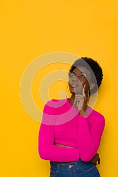 Pansive Young Black Woman Is Holding Hand On Chin And Looking Up