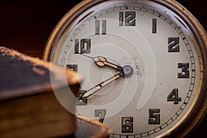 Panta rhei concept: antique pocket watch and pile of vintage hard cover books on natural stone