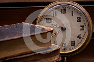 Panta rhei concept: antique pocket watch and pile of vintage hard cover books on natural stone