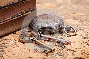 Panta rhei concept: Antique pocket watch, vintage keys and pile of old books on natural cork