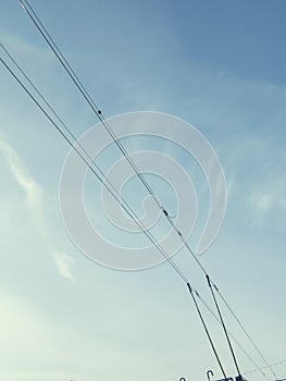 Pantograph of trolleybus on the blue sky background