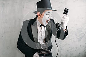 Pantomime actor performing with retro telephone