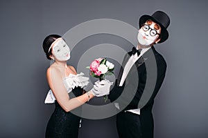 Pantomime actors performing with flower bouquet