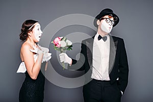 Pantomime actors performing with flower bouquet photo