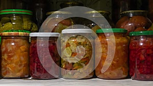 Pantry shelf with provisions in glass jars with pickled vegetables