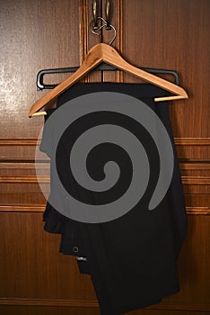 Pants on a wooden hanger. Folded blue trousers