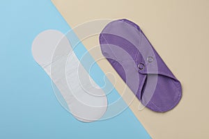 Pantyliner and reusable menstrual pad on color background, flat lay