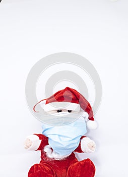 Homemade cotton Santa Claus play with a Covid-19 or Coronavirus protection mask photo
