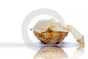 Papad or papadum in a clay bowl isolated on white with its reflection.