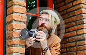 Paparazzi taking picture with photocamera. Bearded man with photo camera. Photojournalist. Detective.