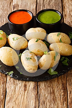 Papas arrugadas wrinkly potatoes is a traditional boiled potato dish served with a mojo rojo and mojo verde sauces close up in the