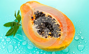 Papaya fruit on blue background with water drops, fresh exotic fruits design