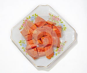 Papaya fruit in dish on white background