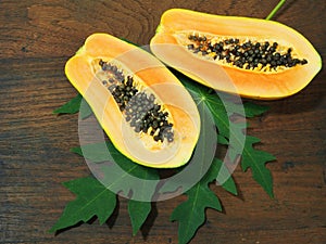 Papaya with green leaf on wooden background