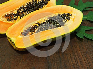 Papaya with green leaf on wooden background