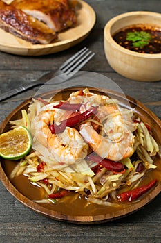 Papaya salad with pickled fish soup and shrimp in wooden table on wooden table