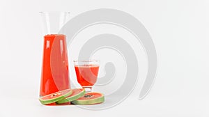 Papaya smoothie in glass jar and glasses on white background