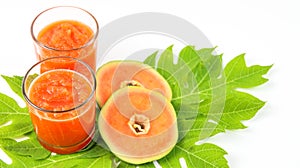 Papaya smoothie in glass jar and glasses on white background