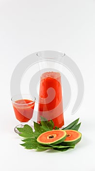 Papaya smoothie in glass jar and glasses on white background