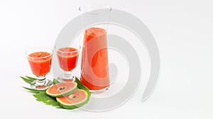 Papaya smoothie in glass jar and glasses on white background