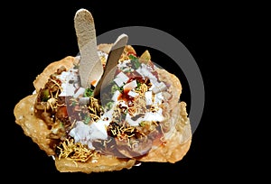 Papdi chaat indian spicy snack isolated in black background