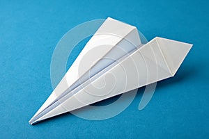Paper airplane on blue paper background