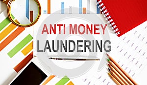 Paper with Anti-money laundering AML on chart with office tools