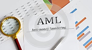 Paper with Anti-money laundering AML on a table with business chart