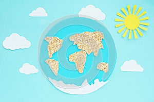 paper application: planet Earth, continents, clouds and the sun on a blue background.