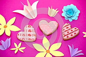 Paper art, bright handmade summer holiday flowers, craft on a pink background with cookies in the form of hearts