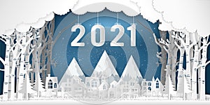 Paper art and cut of year 2021 in the winter season with trees , forest and snow village on the blue sky as Happy New Year 2021