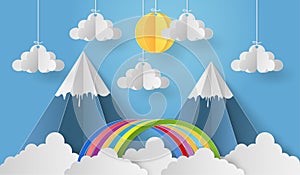 Paper art of mobile paper sun and cloud with mountain and rainbow on blue sky backgrond