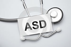 Paper with asd on a table and grey stethoscope