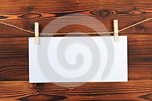 Paper attach to rope with clothes pins on wooden background - Image