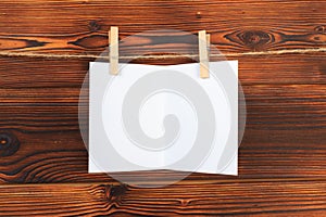 Paper attach to rope with clothes pins on wooden background - Image