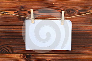 Paper attach to rope with clothes pins on wooden background - Image