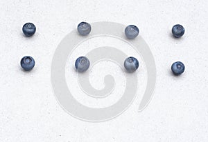 Paper background with blue bilberries. Suitable design element for seasonal greeting, card, banner