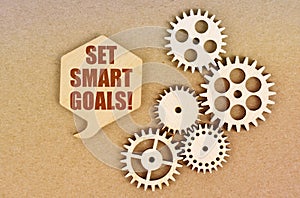 On a paper background, gears and a thought plate with the inscription - Set Smart Goals