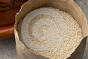 Paper bag with barley grits close up photo