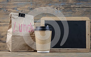 Paper bag and blackboard on wood background with a notes lunch